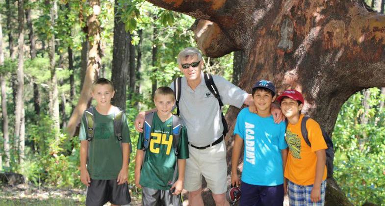 Larry Smith, himself a twin, posing with sixth grade twins in front of Jacksonville's oldest and largest Madrone Tree. Photo by Larry B. Smith.