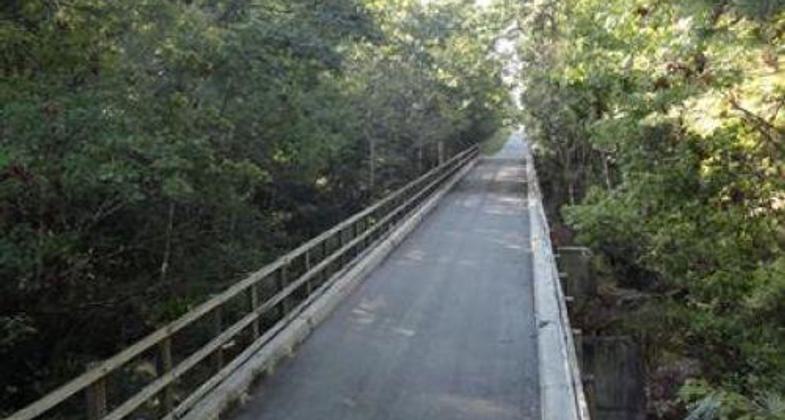 Cyclists take the bridge along this very straight trail.