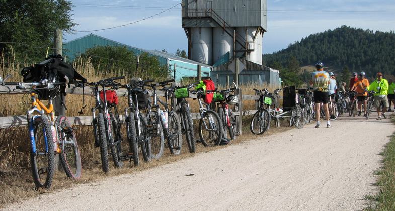 Bicycles lined up along the fence at Pringle. One of the Trailheads along the Mickelson Trail. Photo by Brooke Smith.