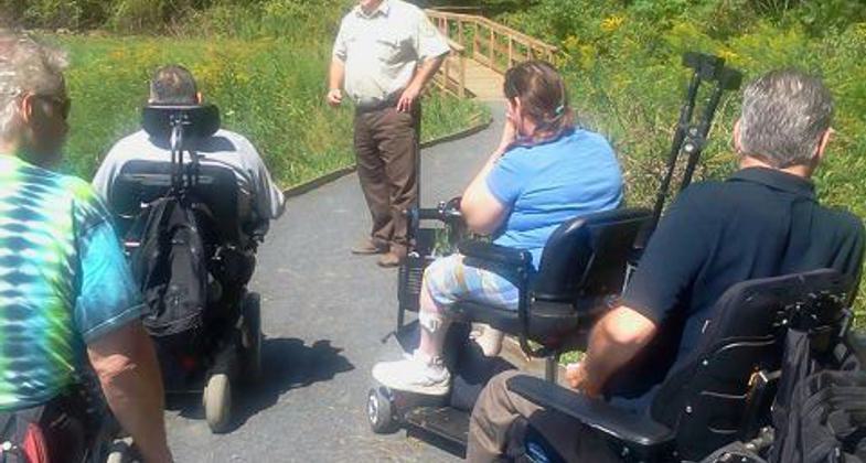 A group of students explore the world of macro-invertebrates while on a field trip to the Fort River Trail.