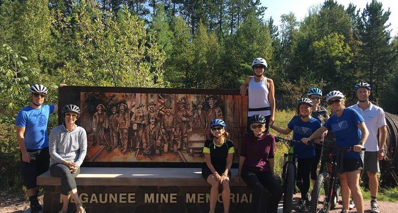 Bike riders stopping by the Negaunee MIne Memorial to honor those lost in underground mine cave in. Photo by Carol Fulsher.