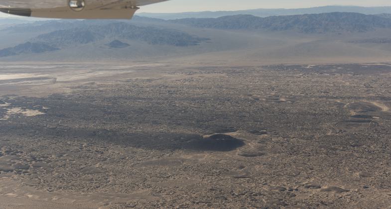 Photo by Kyle Sullivan. An Ecoflight soars above Amboy Crater in January 2019.