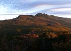 Raven Rocks and Calloway Peak, as the rising sun illuminates the brilliant fall foliage on the southeastern face of Grandfather. Photo by Ken Thomas.