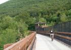 The bridge carrying the Lehigh Gorge Trail and a railroad over the Lehigh River in Jim Thorpe, PA. Photo by Listroiderbob2.